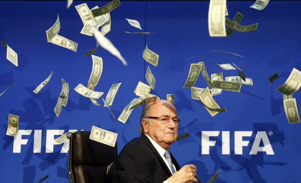 British comedian known as Lee Nelson (unseen) throws banknotes at FIFA President Sepp Blatter as he arrives for a news conference after the Extraordinary FIFA Executive Committee Meeting at the FIFA headquarters in Zurich, Switzerland July 20, 2015. World football's troubled governing body FIFA will vote for a new president, to replace Sepp Blatter, at a special congress to be held on February 26 in Zurich, the organisation said on Monday. REUTERS/Arnd Wiegmann TPX IMAGES OF THE DAY - RTX1L1TH